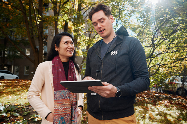 Helen employee is showing energy data from a tablet to a customer